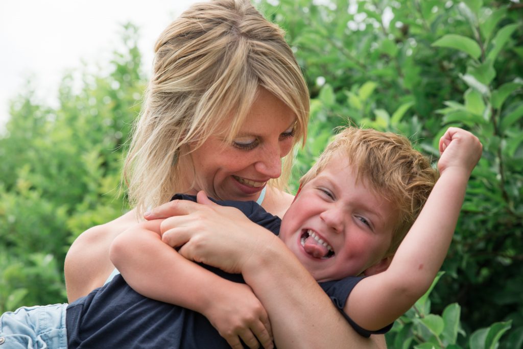 moeder en zoon tijdens een fotoreportage gezin in de boomgaard in Elden